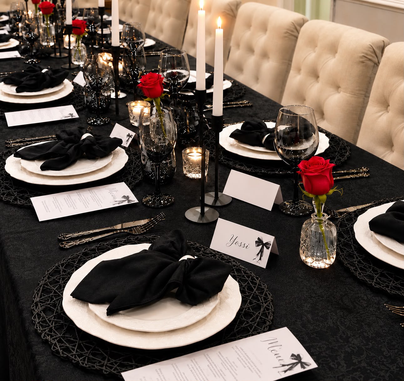 A dramatic Tied with a Bow tablescape in deep black tones with candlelight, florals, and layered place settings